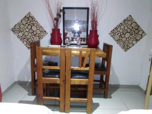 a table with two red vases on top of it at Maditselanyane Guest House in Kuruman