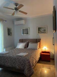een slaapkamer met een bed en een plafondventilator bij My Paradise in Asíni