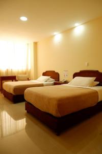 ein Hotelzimmer mit 2 Betten und einem Fenster in der Unterkunft Hotel Maria Gloria in Villavicencio