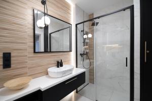 a bathroom with a sink and a glass shower at Apartament Sosnowy przy Basenach Tropikalnych, prywatny parking in Kielce +29 photos