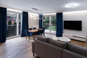 a living room with a couch and a table at Apartament Sosnowy przy Basenach Tropikalnych, prywatny parking in Kielce