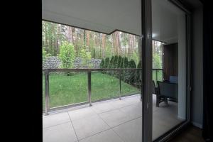 een open deur naar een balkon met uitzicht op een tuin bij Apartament Sosnowy przy Basenach Tropikalnych, prywatny parking, faktura in Kielce