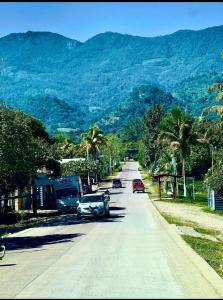 een straat met auto's die over een weg met bergen rijden bij Cabaña de campo en el lago de yojoa in Santa Cruz de Yojoa