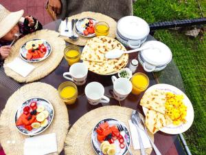 a table with plates of food and glasses of orange juice at Sol y Luna Glamping in Málaga