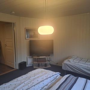 1 dormitorio con 2 camas y TV de pantalla plana en GG overnatting en Stavanger