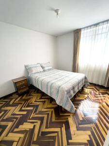 1 dormitorio con cama y alfombra en Casa Vallecito, en Arequipa