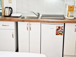 blat kuchenny ze zlewem i białymi szafkami w obiekcie Olympio Luxury Studio Paros w mieście Paros