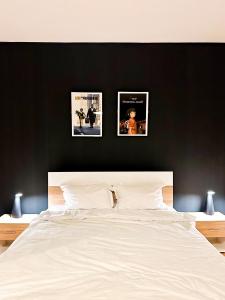 three pictures on a black wall above a bed at Serenity House Apartments in Sibiu
