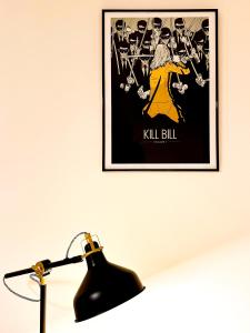 a poster of kill bill on a wall next to a lamp at Serenity House Apartments in Sibiu