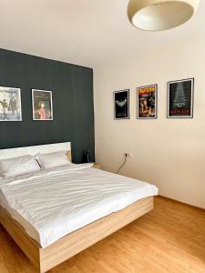 1 dormitorio con 1 cama blanca grande y pared negra en Serenity House Apartments en Sibiu