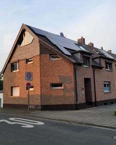 ein Backsteingebäude mit einem Sonnendach auf einer Straße in der Unterkunft Messezimmer am Thewissenweg in Düsseldorf