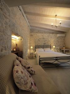 a bedroom with two beds and a stone wall at Sophia Areopoli Guesthouse in Areopolis