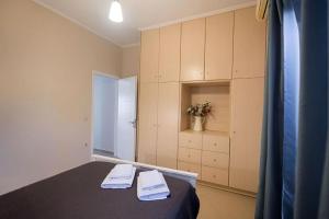 a bedroom with a bed and a cabinet with towels at La Strada Apartment in Lefkada +40 photos