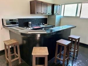 a kitchen with a counter and two stools at Hotel Aqualuna Departamento #aussiepipe in Puerto Escondido