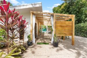 uma entrada para o jardim de uma casa com uma pérgula de madeira em Casa Sunshine y Palmeras em Matapalo