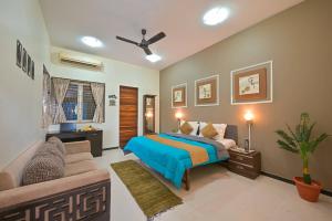 una camera da letto con un letto e un divano di Fortune Villa by Tropicana Stays a Lonavala Altre 49 foto