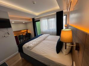 een slaapkamer met een bed met een lamp en een tafel bij The Blue Suites in Istanbul