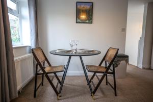 a table with two chairs and wine glasses on it at Cozy 1-BR Sanctuary in Redland, Bristol in Bristol