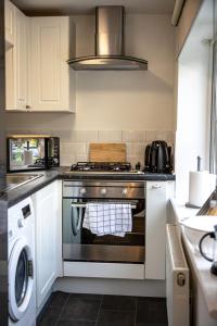 a kitchen with a stove and a washing machine at Cozy 1-BR Sanctuary in Redland, Bristol in Bristol