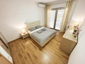 a small bedroom with a bed and two tables at Currilave 664 in Durrës