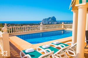 balcón con sillas y piscina en Villa Gran Sol by Abahana Villas, en Calpe