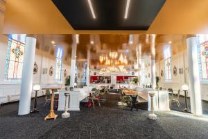 a room with tables and chairs and stained glass windows at Le Saint-Crème, Alma in Alma