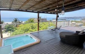 a hot tub on a deck with a view of the ocean at Hotel Aqualuna Departamento #aussiepipe in Puerto Escondido