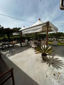 eine Terrasse mit einem Tisch, Stühlen und einem Pavillon in der Unterkunft IG House - Apartment Cavallino Treporti in Cavallino-Treporti