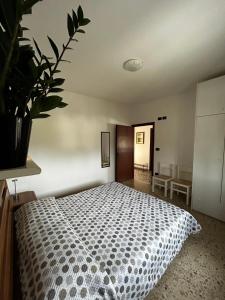 ein Schlafzimmer mit einem Bett und einer Pflanze in der Unterkunft IG House - Apartment Cavallino Treporti in Cavallino-Treporti