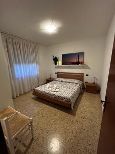 Schlafzimmer mit einem Bett und einem Flachbild-TV in der Unterkunft IG House - Apartment Cavallino Treporti in Cavallino-Treporti