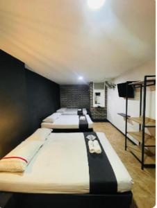 a bedroom with two beds and a tv at Hotel Panorama Center in Medellín