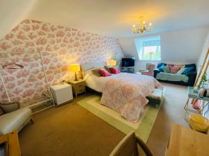 ein Schlafzimmer mit einem Bett, einem Stuhl und einem Sofa in der Unterkunft Number 2, Spacious Rooms, Near Ironbridge! in Telford