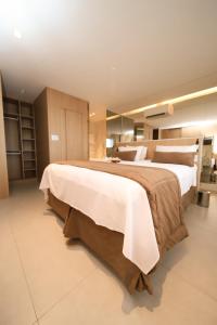 een grote slaapkamer met 2 bedden met witte lakens bij Marano Hotel in Salvador