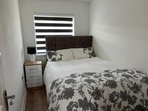 sypialnia z łóżkiem z czarno-białym kocem w obiekcie Exclusive 3 Bed Home-5 mins from Lakeside Shopping Mall w mieście West Thurrock