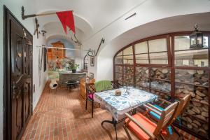 a room with a table and chairs and a stone wall at Kordé Apartman in Kőszeg