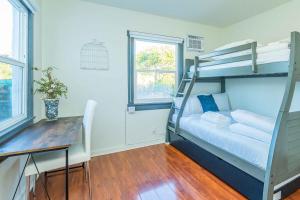 Cette chambre dispose de lits superposés, d'une table et d'un bureau. dans l'établissement Newly Remodeled 3B2B House, à Glendora