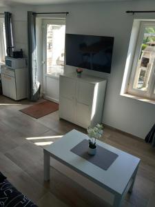 a living room with a table and a refrigerator at Petite maison du Tronquay in Le Tronquay +5 photos