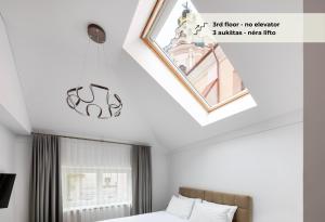 - une chambre avec un lit et un lustre dans l'établissement GRAND CROWN, à Vilnius