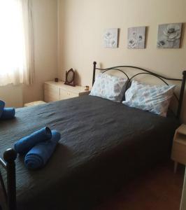 a bedroom with a large bed with blue pillows at House Eleni in Kranidi