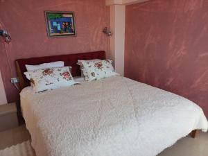 1 dormitorio con 1 cama con sábanas y almohadas blancas en ZafireniaSuites en Elevtheraí