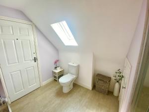 a bathroom with a toilet and a skylight at Number 2, Spacious Rooms, Near Ironbridge! in Telford