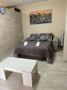 um quarto com uma cama, uma mesa e um relógio em Casetta in villa indipendente em Angri