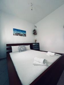 1 dormitorio con 1 cama blanca grande y toallas. en Ocean View Apartments, en Vrasná