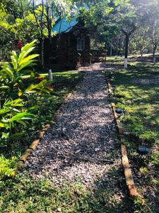 einen Schotterweg, der zu einer Hütte in einem Park führt in der Unterkunft Cabaña de campo en el lago de yojoa in Santa Cruz de Yojoa