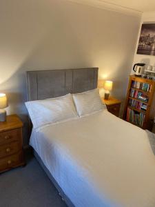 una camera da letto con un grande letto bianco con due comodini di Orchard Views a North Hykeham