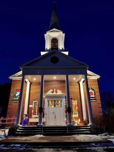 Une église avec des lumières de Noël à l'avant dans l'établissement Le Saint-Crème, à Alma
