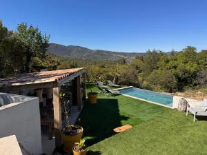 a backyard with a swimming pool and a house at La forêt in Plan-de-la-Tour