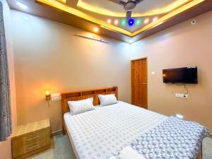 a bedroom with a bed and a tv on the ceiling at JFZ Homestay in Honāvar