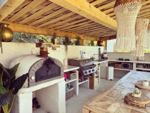 a large outdoor kitchen with a fireplace and a stove at La forêt in Plan-de-la-Tour