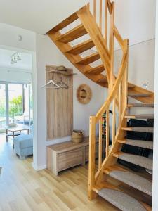 uma escada de madeira numa sala de estar com uma mesa em Porto 13 - TRZĘSACZ SUNNY SIDE BALTIC em Trzęsacz